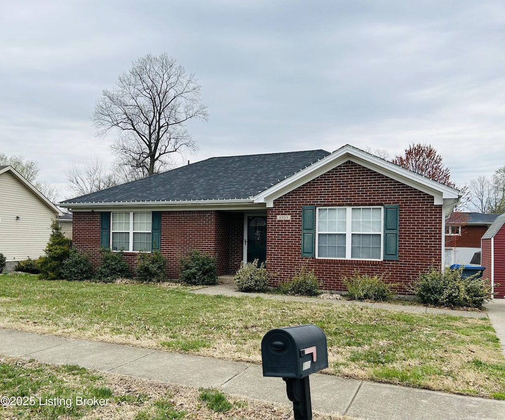 single story home with a front lawn, brick siding, and roof with shingles