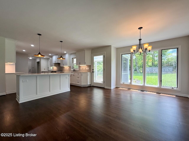 kitchen featuring dark wood-style flooring, plenty of natural light, a chandelier, baseboards, and recessed lighting