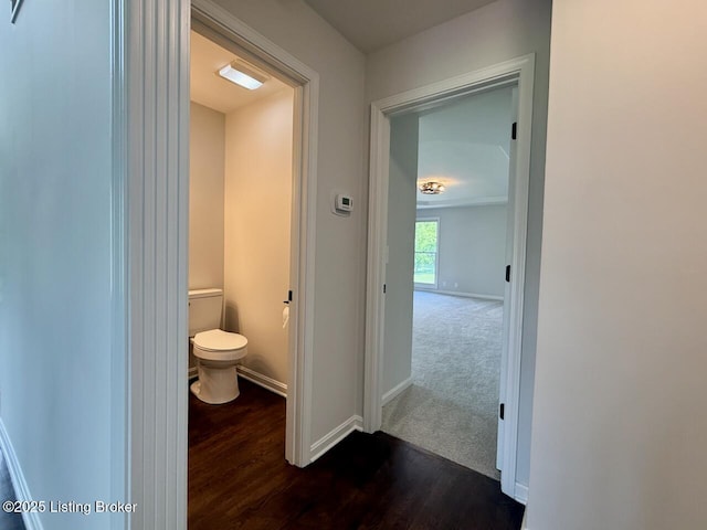 bathroom with toilet, wood finished floors, and baseboards