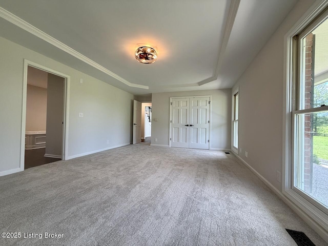 unfurnished bedroom featuring carpet flooring, multiple windows, and baseboards