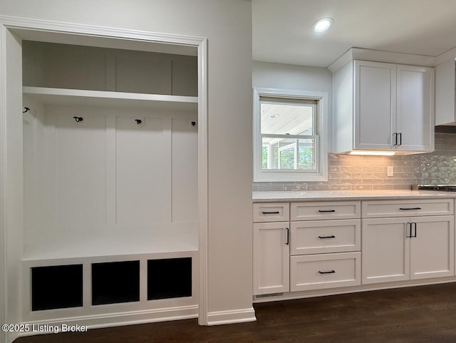 mudroom with dark wood finished floors and recessed lighting