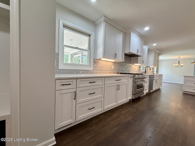 kitchen with stainless steel appliances, dark wood finished floors, baseboards, tasteful backsplash, and recessed lighting