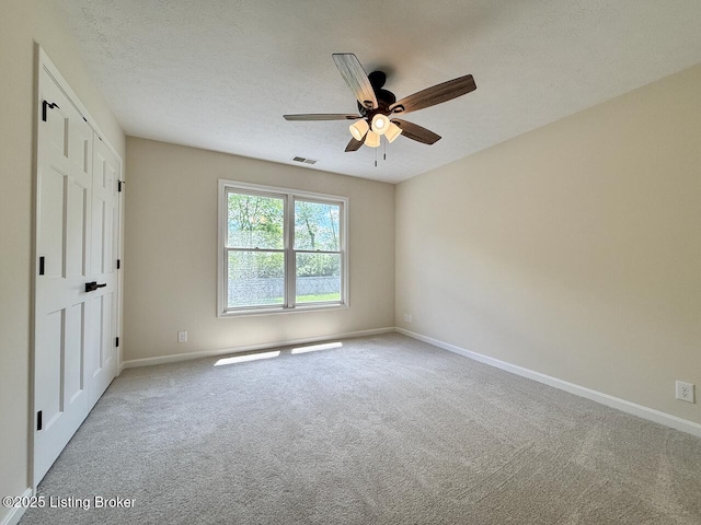 spare room featuring carpet floors, baseboards, and a ceiling fan