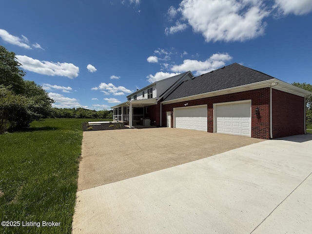 view of front of property featuring brick siding, concrete driveway, a garage, and a front yard
