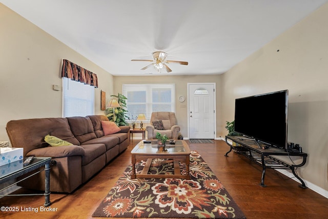 living area with baseboards, ceiling fan, and wood finished floors