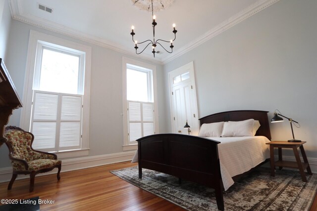 1217 S 4th St, Louisville, KY 40203 - bedroom with a notable chandelier, baseboards, ornamental molding, visible vents, and wood finished floors