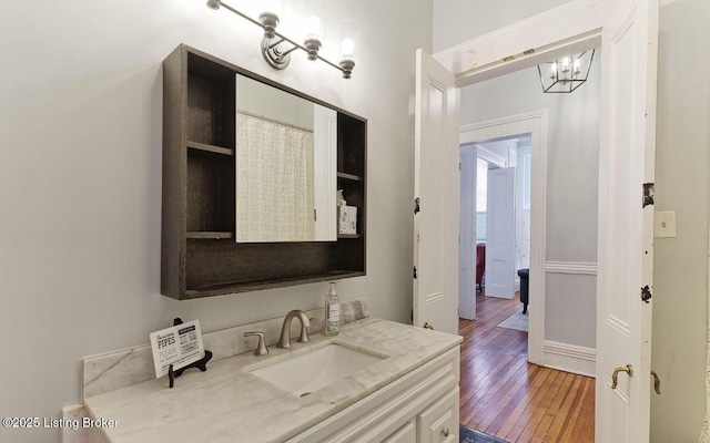1217 S 4th St, Louisville, KY 40203 - bathroom with a chandelier, wood-type flooring, vanity, and baseboards