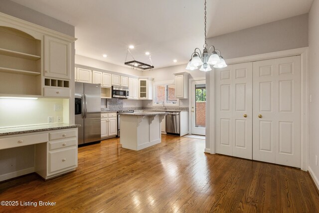 7808 Grenoble Ln, Prospect, KY 40059 - kitchen with stainless steel appliances, a kitchen bar, recessed lighting, a kitchen island, and a sink