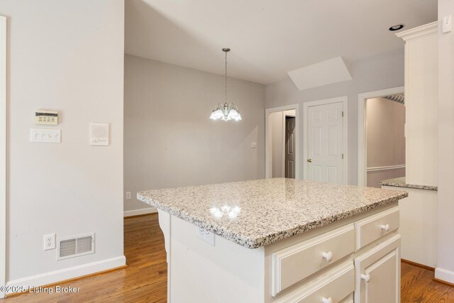 7808 Grenoble Ln, Prospect, KY 40059 - kitchen featuring baseboards, light wood-type flooring, hanging light fixtures, a chandelier, and a center island