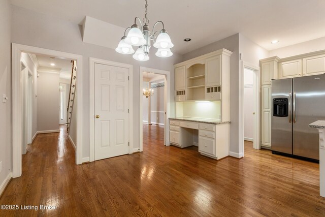 7808 Grenoble Ln, Prospect, KY 40059 - kitchen with stainless steel fridge with ice dispenser, a chandelier, open shelves, wood finished floors, and baseboards