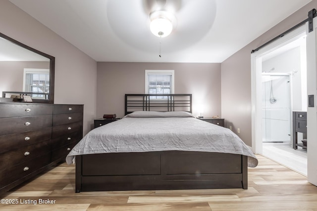 432 Four Seasons Rd, Falls Of Rough, KY 40119 - bedroom featuring light wood finished floors, a barn door, connected bathroom, and a ceiling fan