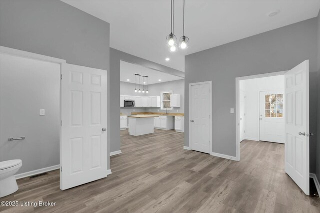 2203 Date St, Louisville, KY 40210 - unfurnished living room featuring baseboards, visible vents, recessed lighting, and wood finished floors