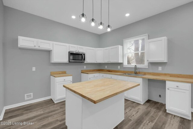 2203 Date St, Louisville, KY 40210 - kitchen featuring a sink, stainless steel microwave, butcher block counters, and wood finished floors