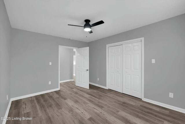 2203 Date St, Louisville, KY 40210 - unfurnished bedroom featuring baseboards, wood finished floors, a closet, and a ceiling fan