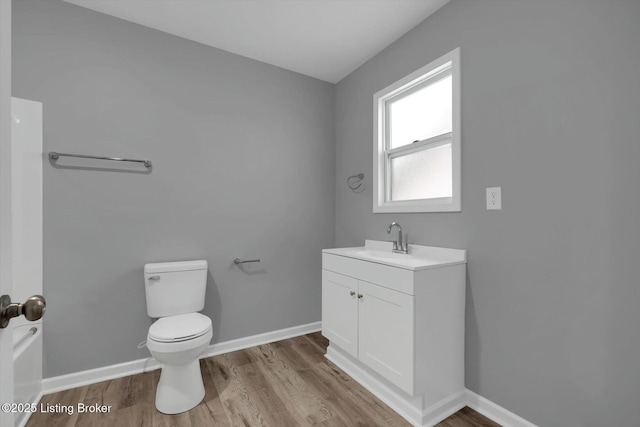 2203 Date St, Louisville, KY 40210 - bathroom featuring baseboards, wood finished floors, toilet, and vanity