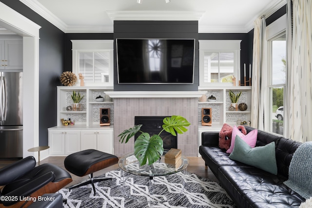 living area with a fireplace, ornamental molding, and plenty of natural light