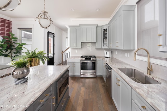 kitchen with dark wood-style flooring, light stone counters, glass insert cabinets, appliances with stainless steel finishes, and a sink