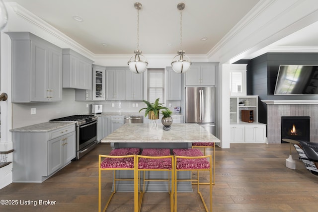 kitchen featuring a kitchen bar, dark wood-type flooring, light stone counters, and stainless steel appliances