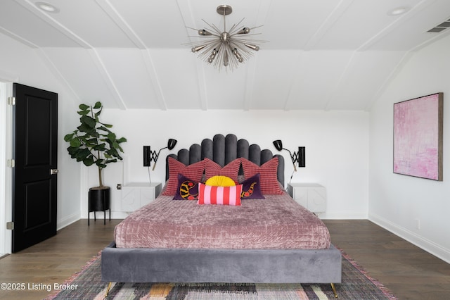 bedroom featuring baseboards, wood finished floors, and lofted ceiling