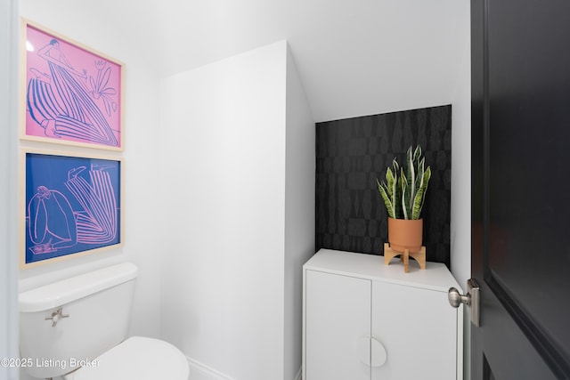 bathroom with toilet and lofted ceiling