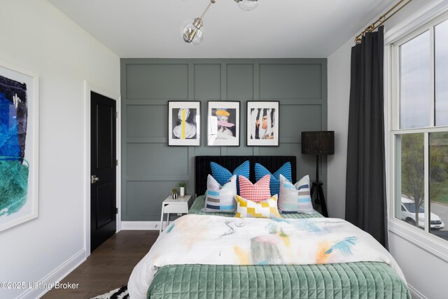 bedroom with dark wood-style flooring and baseboards