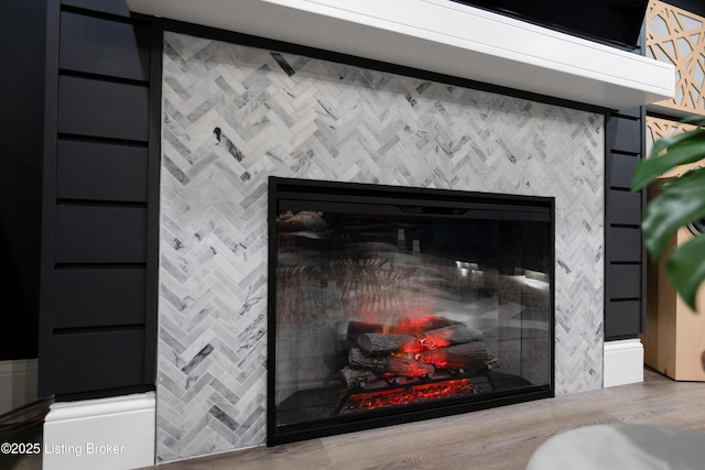 interior details featuring wood finished floors and a glass covered fireplace