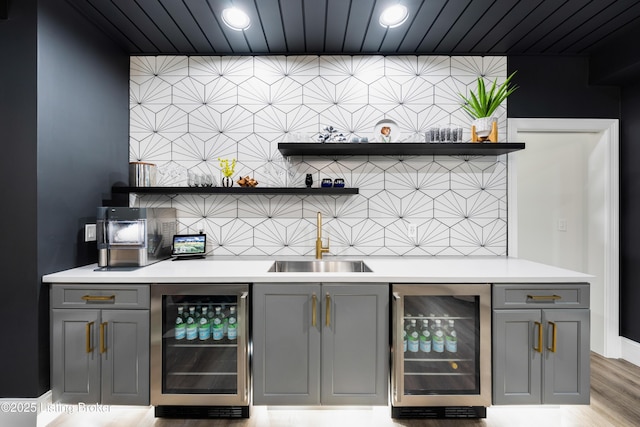 bar featuring a sink, beverage cooler, and bar