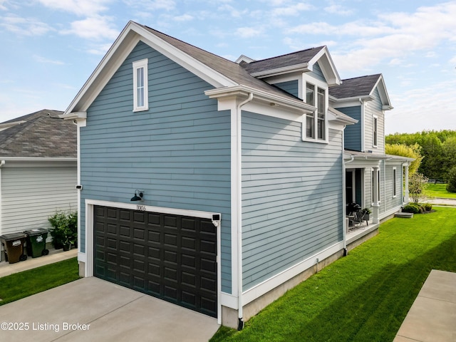 view of side of home featuring an attached garage, driveway, and a lawn