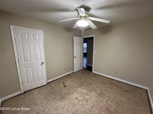 unfurnished bedroom featuring a textured ceiling, baseboards, ceiling fan, and visible vents