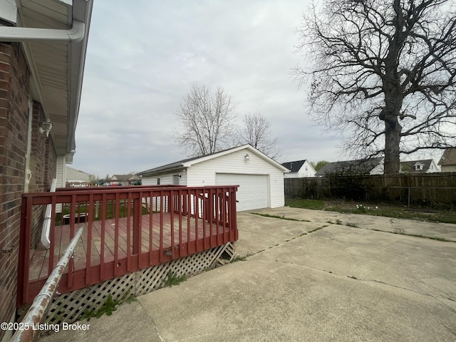exterior space with an outbuilding, fence, a detached garage, and a deck