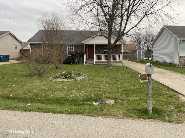 view of front facade featuring driveway, a front yard, covered porch, an outbuilding, and brick siding