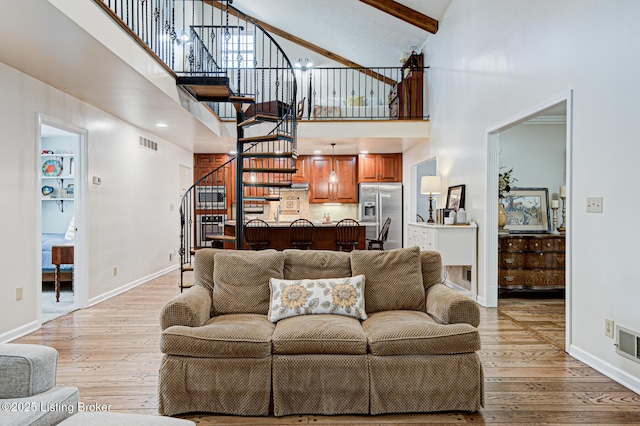 1014 Old Mill Stream Ln, Shepherdsville, KY 40165 - living area featuring high vaulted ceiling, stairway, light wood finished floors, baseboards, and beam ceiling