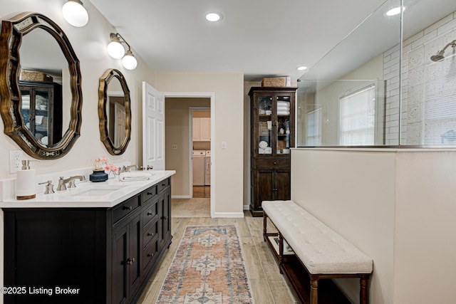1014 Old Mill Stream Ln, Shepherdsville, KY 40165 - bathroom with washing machine and clothes dryer, double vanity, a tile shower, recessed lighting, and wood finished floors