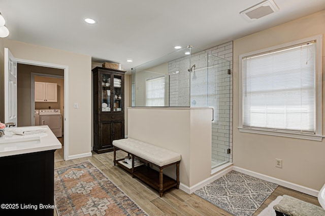 1014 Old Mill Stream Ln, Shepherdsville, KY 40165 - full bath with washing machine and dryer, a shower stall, vanity, wood finished floors, and baseboards
