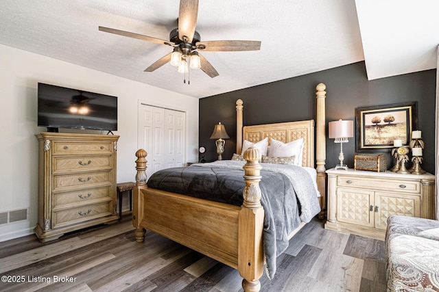 bedroom with visible vents, a closet, light wood-type flooring, a textured ceiling, and a ceiling fan