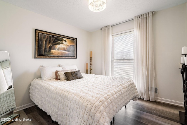 bedroom with baseboards, dark wood-style flooring, and visible vents