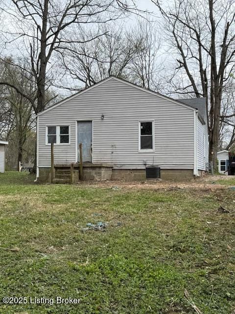 rear view of house featuring a lawn and central AC