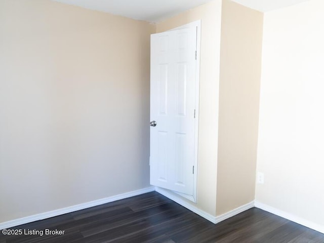 unfurnished room featuring dark wood-style floors and baseboards