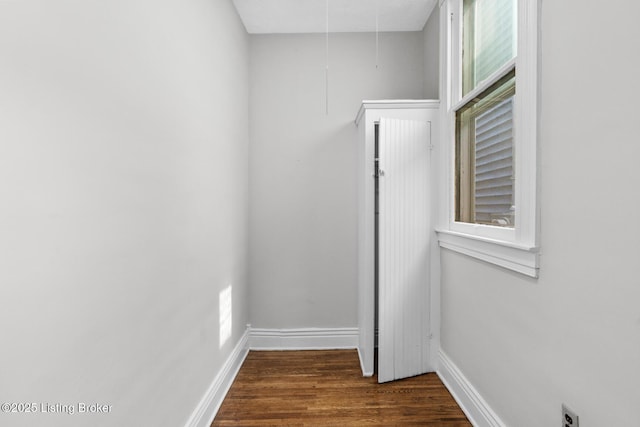 spare room featuring dark wood-style flooring, baseboards, and attic access