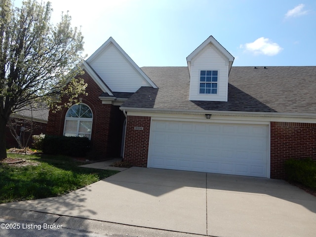 113 Lanai Dr Unit A, Shepherdsville, KY 40165 - view of front facade with an attached garage, a shingled roof, concrete driveway, and brick siding