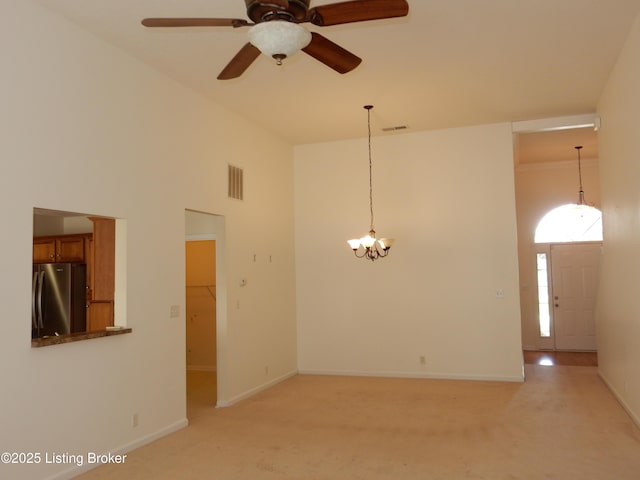 113 Lanai Dr Unit A, Shepherdsville, KY 40165 - spare room featuring light colored carpet, ceiling fan with notable chandelier, baseboards, a high ceiling, and visible vents
