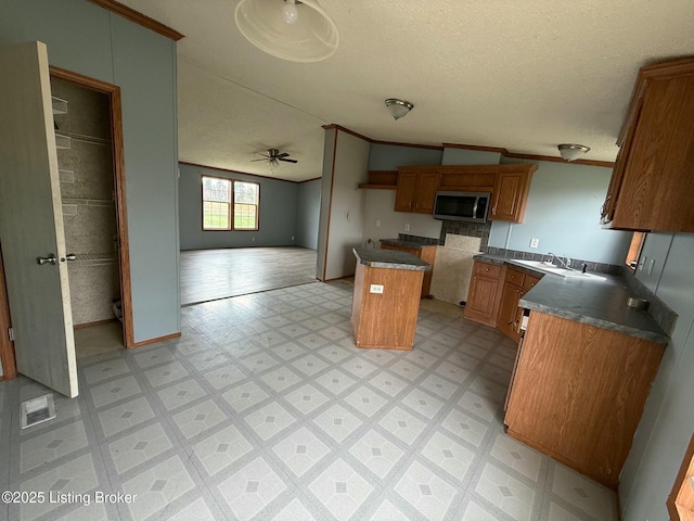 42 Foggy Bottom Ln, Garfield, KY 40140 - kitchen with crown molding, light floors, a textured ceiling, a center island, and stainless steel microwave