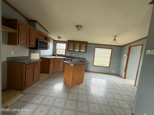 42 Foggy Bottom Ln, Garfield, KY 40140 - kitchen with brown cabinetry, light floors, ornamental molding, and stainless steel microwave
