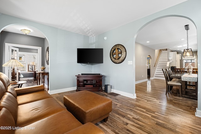 4613 S 2nd St, Louisville, KY 40214 - living room featuring stairs, arched walkways, wood finished floors, and baseboards