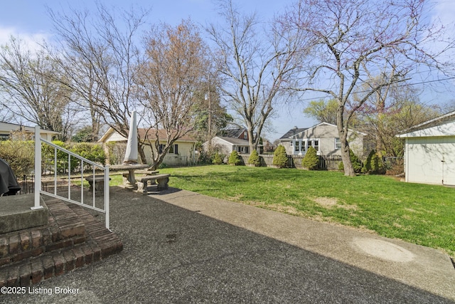 view of yard featuring an outbuilding, fence, and a residential view