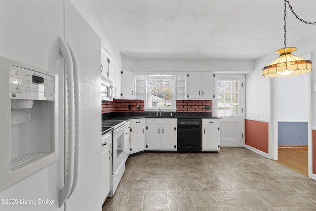 kitchen featuring open shelves, a sink, dark countertops, white appliances, and white cabinetry