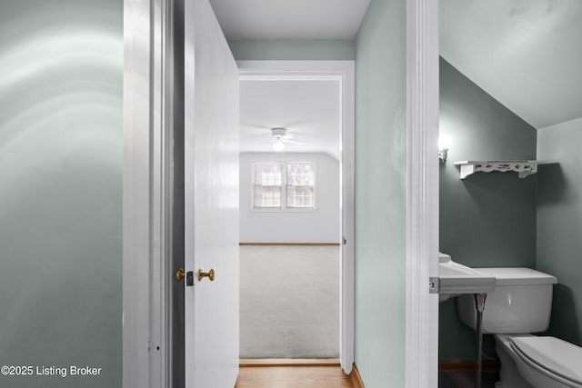 bathroom featuring toilet, wood finished floors, a ceiling fan, and vaulted ceiling