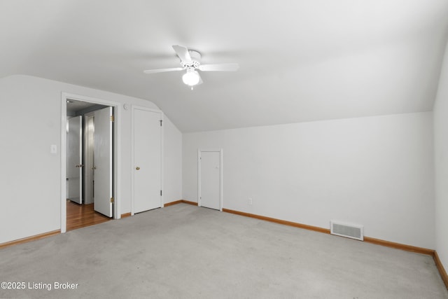 additional living space featuring visible vents, vaulted ceiling, and carpet floors