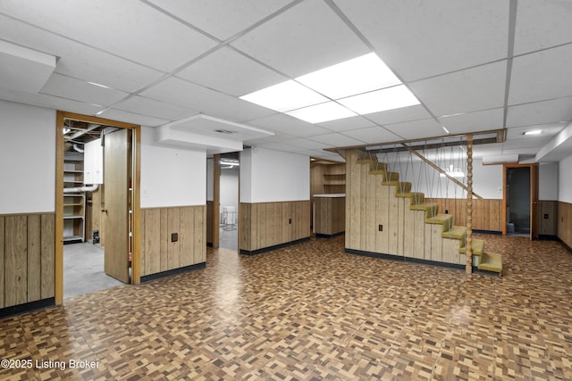 finished basement with wood walls and a wainscoted wall