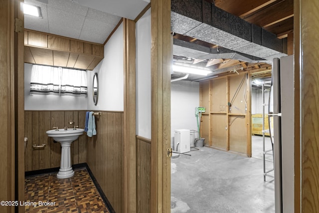 bathroom with wooden walls and a wainscoted wall